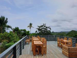 a wooden deck with wooden tables and chairs on it at Casa Cantagalo - Guest House & Bar Restaurant in Santana