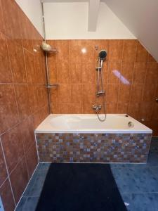 Das Bad ist mit einer Badewanne mit einer Dusche ausgestattet. in der Unterkunft Pension 43 in Duisburg