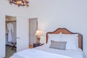 a bedroom with a white bed and a lamp at 3263 Villa by the Sea townhouse in Pacific Grove