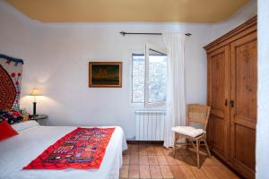 una camera da letto con un letto, una sedia e una finestra di Flateli Sa Tuna 3 a Begur