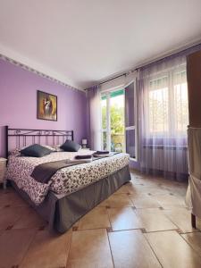 una camera con un grande letto e pareti viola di Ca' Barozzi a Venezia