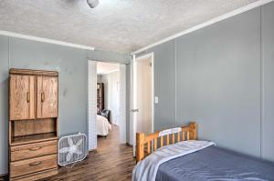 um quarto com paredes azuis, uma cama e uma ventoinha em Lakefront Shelby Vacation Rental with Game Room! em Shelby