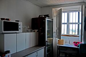a kitchen with a microwave on top of a counter at Guesthouse da Sé in Guarda