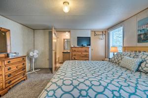a bedroom with a large bed and a television at Peaceful Supply House about 2 Mi to Holden Beach! in Supply