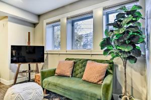 un sofá verde en una sala de estar con ventanas en Walkable Portland Studio Less Than 1 Mi to Dtwn! en Portland
