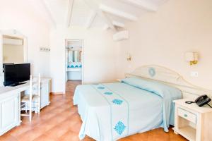 a white bedroom with a bed and a television at Marina Torre Navarrese Resort in Santa Maria Navarrese