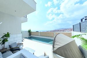 埃拉特VILA ME的从房子的阳台上可欣赏到游泳池的景色