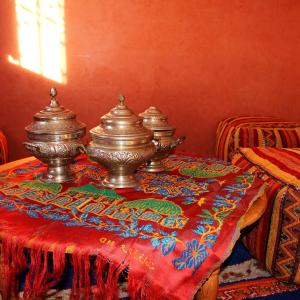 zwei silberne Töpfe auf einem Tisch mit einer roten Decke in der Unterkunft Pergolas Tamakouchte in Ouarzazate
