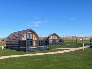 two large cottages in a park with grass at Pentire Coastal Holiday Park in Bude