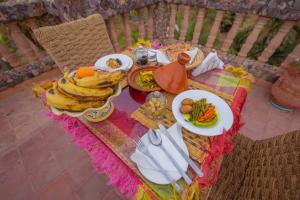 einen Tisch mit Teller mit Speisen darüber in der Unterkunft Pergolas Tamakouchte in Ouarzazate