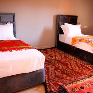 2 Betten nebeneinander in einem Zimmer in der Unterkunft Pergolas Tamakouchte in Ouarzazate
