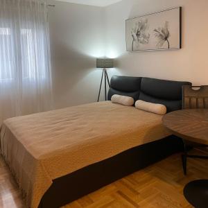 a bedroom with a large bed and a table at Apartman TIM LUX 1 in Vrnjačka Banja