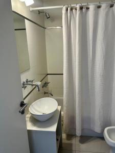 baño con lavabo y cortina de ducha blanca en Departamento de Lujo Belgrano 7A en Buenos Aires