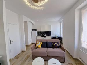 een woonkamer met een bank en een keuken bij Gregbnb-com - T2 37m2 -1- Est - in Toulon