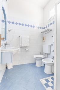 a white bathroom with two toilets and a sink at Hotel Fantini in Gatteo a Mare