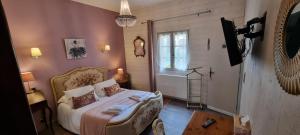 a bedroom with a bed with a chair and a window at Le Domaine du Terroir à 5 minutes des Grottes de Lascaux in La Chapelle-Aubareil