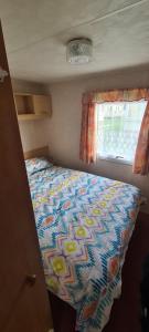 a bedroom with a bed in a small room at Eastgate Fantasy Islands Static Caravan Park in Ingoldmells