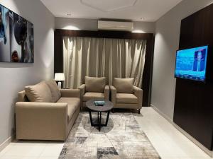 شقق البندقية للوحدات الفندقية ALBUNDUQI HOTEl في الرياض: غرفة معيشة مع كنبتين وتلفزيون بشاشة مسطحة