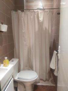 y baño con cortina de ducha blanca y aseo. en Entire Apartment, en Agadir