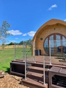eine große Holzhütte mit einer Holztreppe und einer Tür in der Unterkunft Finest Retreats - Deep Dale in York