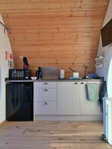 a kitchen with white cabinets and a black appliance at Finest Retreats - Hundle Dale in York