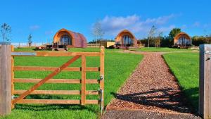 a wooden gate in front of a field with two domes at Finest Retreats - Mingle Dale in York +4 photos