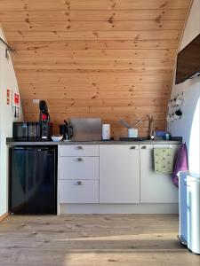 a kitchen with white cabinets and a black dishwasher at Finest Retreats - Mingle Dale in York