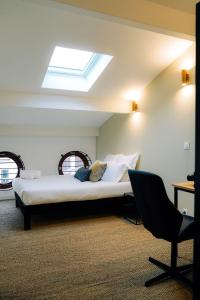 1 dormitorio con 1 cama, 1 silla y 1 ventana en Outsite Bordeaux en Burdeos