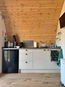 eine Küche mit weißen Schränken und einem schwarzen Geschirrspüler in der Unterkunft Finest Retreats - Worm Dale in York