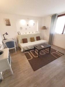 un soggiorno con letto e tavolo di Appartement Franche Valeine a Juan-les-Pins