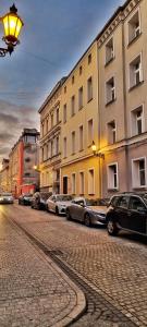 eine Straße mit Autos, die vor den Gebäuden geparkt sind in der Unterkunft Apartament Kaczyniec 10 in Gliwice
