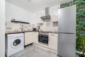 a kitchen with a refrigerator and a washer and dryer at Leicester City Center - TBH in Leicester