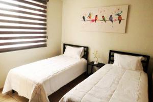 dos camas sentadas una al lado de la otra en un dormitorio en Casa Málaga en Zamora de Hidalgo