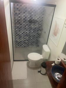 a bathroom with a shower and a toilet and a sink at Pousada Meraki Paraty Mirim in Paraty
