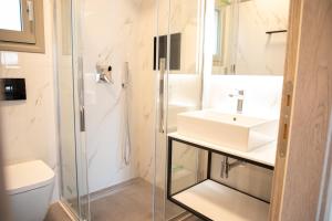 a white bathroom with a sink and a shower at Plataria Sunrise Resort in Plataria