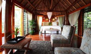 um quarto com uma cama, uma mesa e cadeiras em Namale All Inclusive Resort & Spa em Savusavu