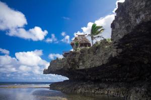 a rock cliff with a house on top of it at Namale All Inclusive Resort & Spa in Savusavu