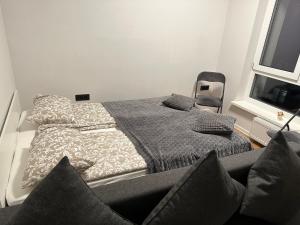 a bedroom with a bed and a chair next to a window at New Ozas flat in Vilnius +17 photos