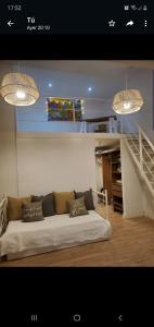 un sofá en una habitación con escalera y 2 luces en pilar tortugas departamento premiun en Pilar
