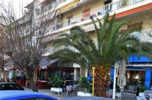 een palmboom voor een gebouw bij Ippokratio Luxury Studio in Thessaloniki