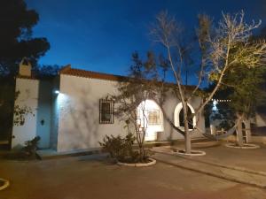 a white building with a tree in front of it at Cortijo Aire del desierto rústico y tranquilo entre el mar y desierto - Alborania in Pechina