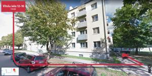 un coche rojo estacionado frente a un edificio en Andrea Apartment en Liepāja