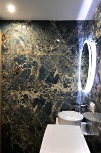 een badkamer met een toilet en een marmeren muur bij Ippokratio Luxury Studio in Thessaloniki