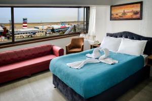特拉布宗的住宿－Elite Holiday Hotel，一间卧室配有一张床、一张沙发和一个窗口