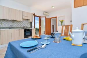 a blue table with plates and utensils on it in a kitchen at Moon Smile in Massa Lubrense