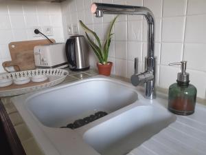 ein Waschbecken in einer Küche mit einem Wasserhahn in der Unterkunft Villa 3 étoiles près des plages, Parking, Wifi, Clim in Sauvian