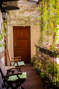 an outdoor patio with two chairs and a door at Kolory Guest House in Kraków