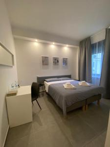 a bedroom with a bed and a desk in it at Residenza Via Verdi in Parma