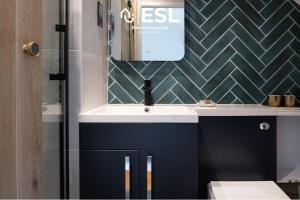 ein Badezimmer mit Waschbecken und Spiegel in der Unterkunft Luxurious 2 Bedroom Countryside Hot Tub Retreat in Stiperstones in Shelve + 33 Fotos