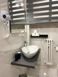 Baño blanco con lavabo y espejo en Residenza Via Verdi en Parma
